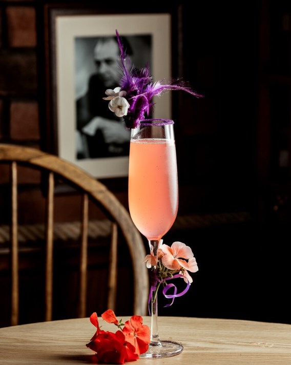 a glass of pink drink decorated with flowers