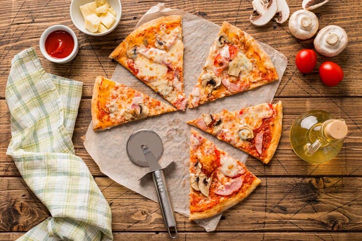 Delicious Pizza with Ingredients on the Wooden Table