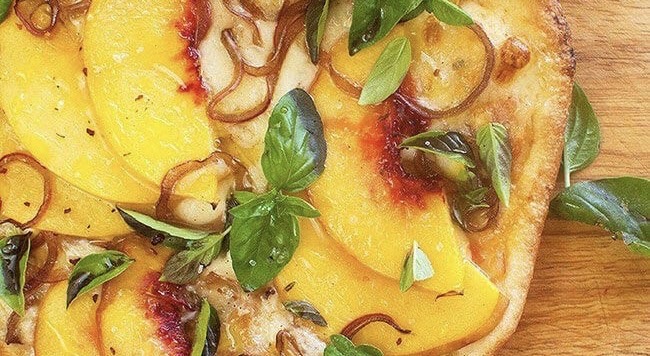 Peach pizza on a wooden table, close up view